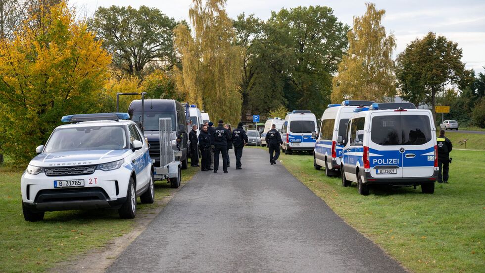 Polizeiautos stehen auf einer Wiese in Tauche. 