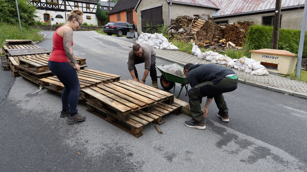 Anwohner bei Aufräumen am Tag nach dem Unwetter.
