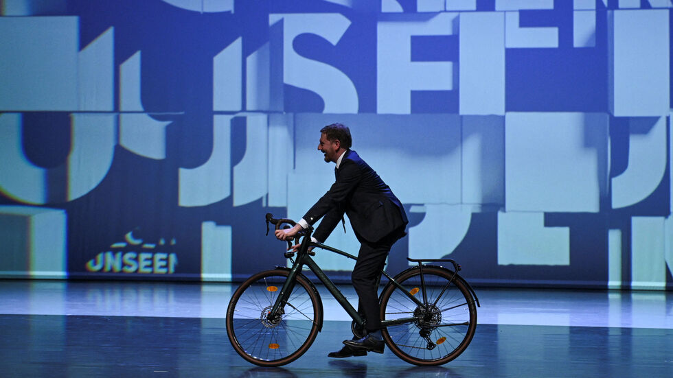 Sachsens Ministerpräsident Michael Kretschmer (CDU) fährt mit dem Fahrrad auf die Bühne vor dem offiziellen Festakt zur Eröffnung Sachsens Ministerpräsident Michael Kretschmer (CDU) fährt mit dem Fahrrad auf die Bühne vor dem offiziellen Festakt zur Eröffnung