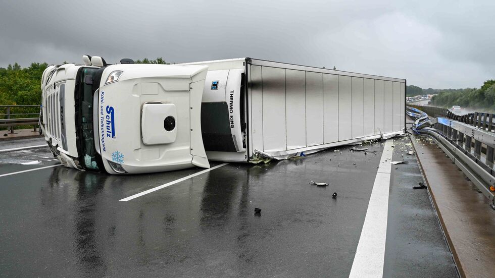 Der Kühllaster liegt auf der Seite, blockiert die Autobahn. Der Kühllaster liegt auf der Seite, blockiert die Autobahn.