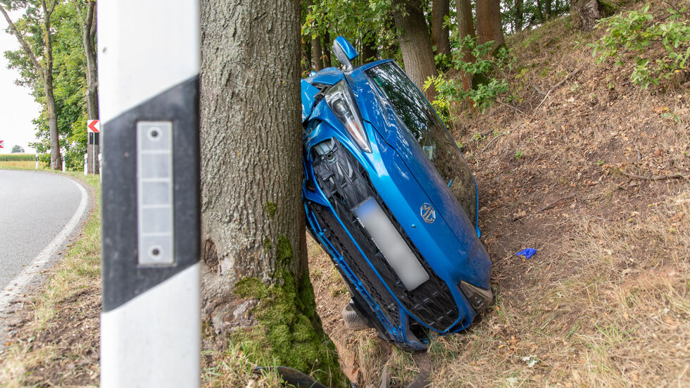 Der blaue MG klemmt zwischen Baum und Hang, der Fahrer verletzte sich nur leicht.