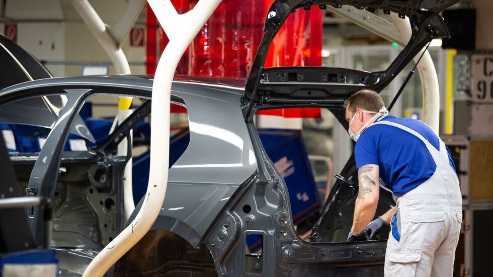 Ein VW-Mitarbeiter arbeitet an der Produktion eines Autos. 
