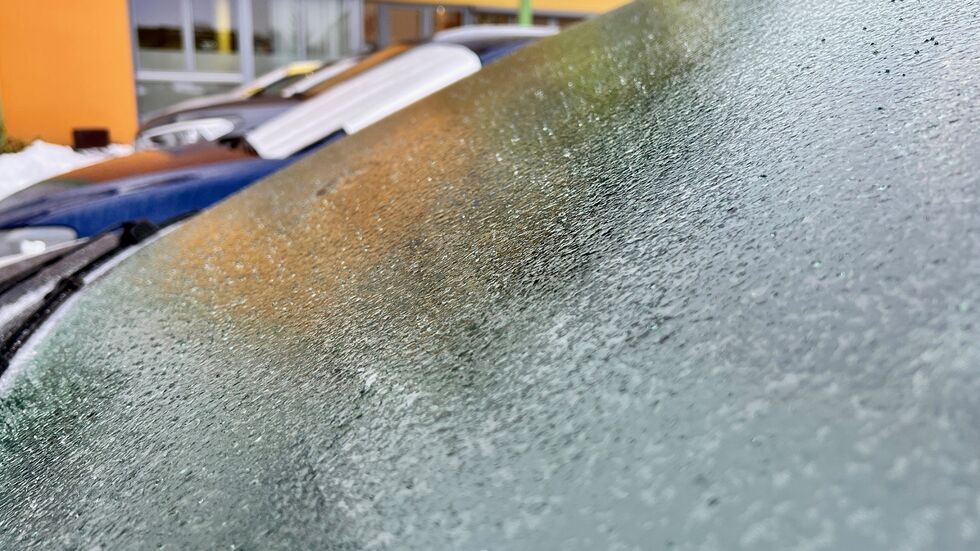 Durch gefrorenen Regen sammeln sich gefrorene Regentropfen an einem Scheibenwischer an einem Auto. Durch gefrorenen Regen sammeln sich gefrorene Regentropfen an einem Scheibenwischer an einem Auto.