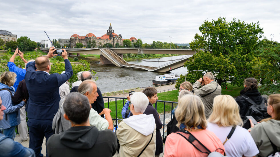 In sicherem Abstand schauen sich die Menschen die eingestürzte Brücke an. In sicherem Abstand schauen sich die Menschen die eingestürzte Brücke an.