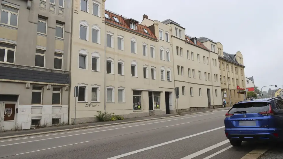 Aus dem Mehrfamilienhaus (Mitte) flogen Armaturen auf die Straße.