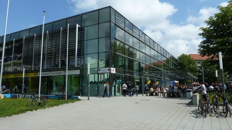 Die Cafeteria befindet sich im Erdgeschoss des Mensa-Gebäudes. Um mehr Platz zu schaffen, ist ein Reisebüro innerhalb der Ladenzeile bereits ein paar Meter weiter umgezogen. Die Cafeteria befindet sich im Erdgeschoss des Mensa-Gebäudes. Um mehr Platz zu schaffen, ist ein Reisebüro innerhalb der Ladenzeile bereits ein paar Meter weiter umgezogen.