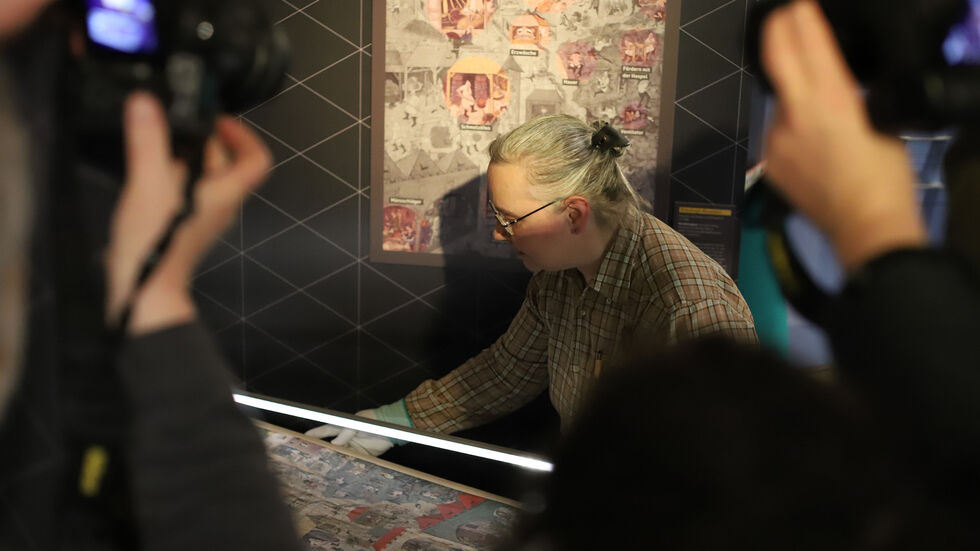 Restauratorin Gabriele Wagner vom Landesamt für Archäologie Sachsen bringt das wertvolle "Wimmelbild" in seine Vitrine in der Sonderausstellung "Silberglanz & Kumpeltod" ein.