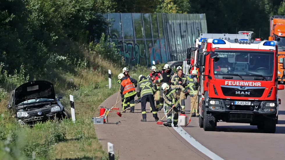 Kameraden der Feuerwehr beim Säubern der Fahrbahn Kameraden der Feuerwehr beim Säubern der Fahrbahn
