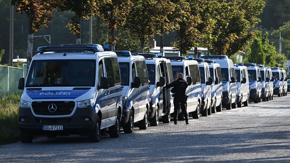 Polizeiautos stehen vor Beginn der Urteilsverkündung gegen Lina E. und drei Männer vor dem Oberlandesgericht (OLG) Dresden