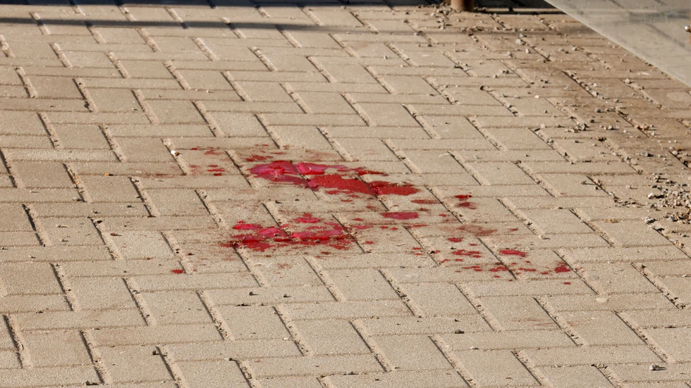 Eine Blutlache auf den Pflastersteinen der Straßenbahnhaltestelle zeugt von dem Unfall.